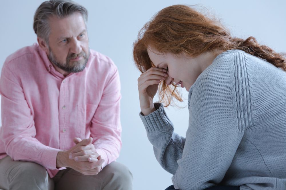 Supportive man comforts woman after abortion experience.
