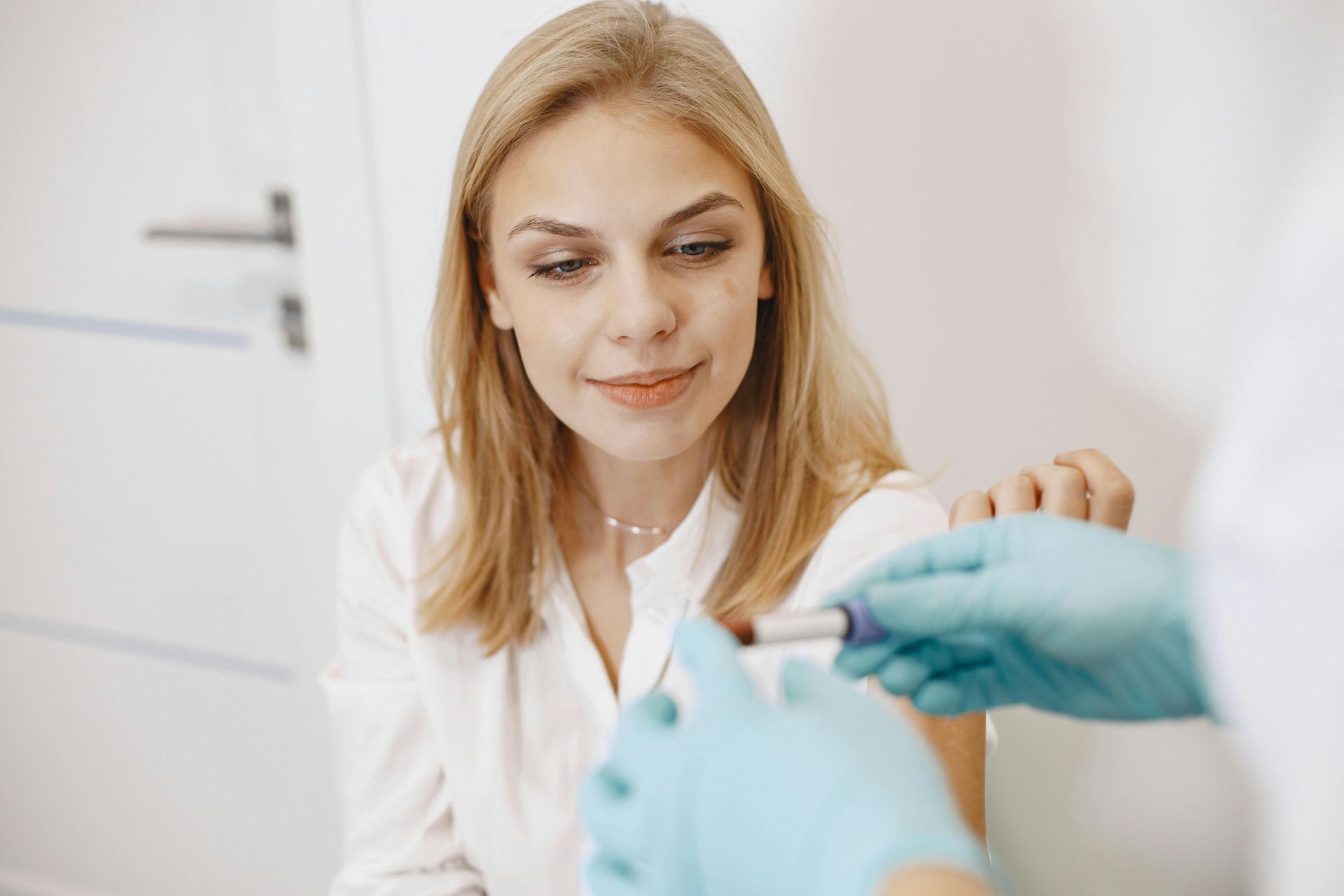 Woman in white blouse, getting her  blood drawn