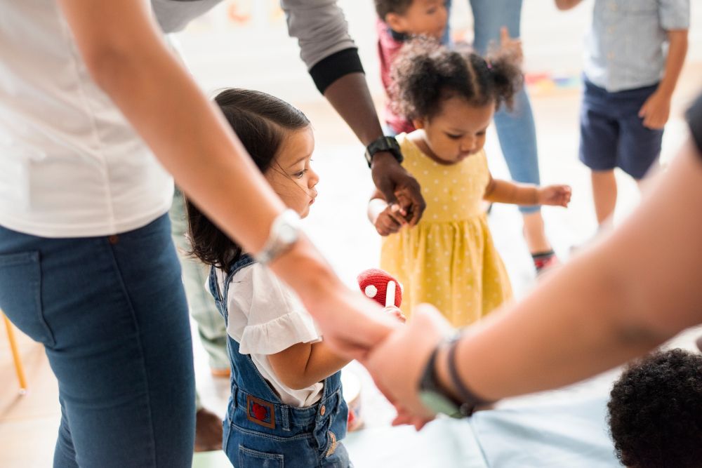 A group of children are holding hands in a circle.