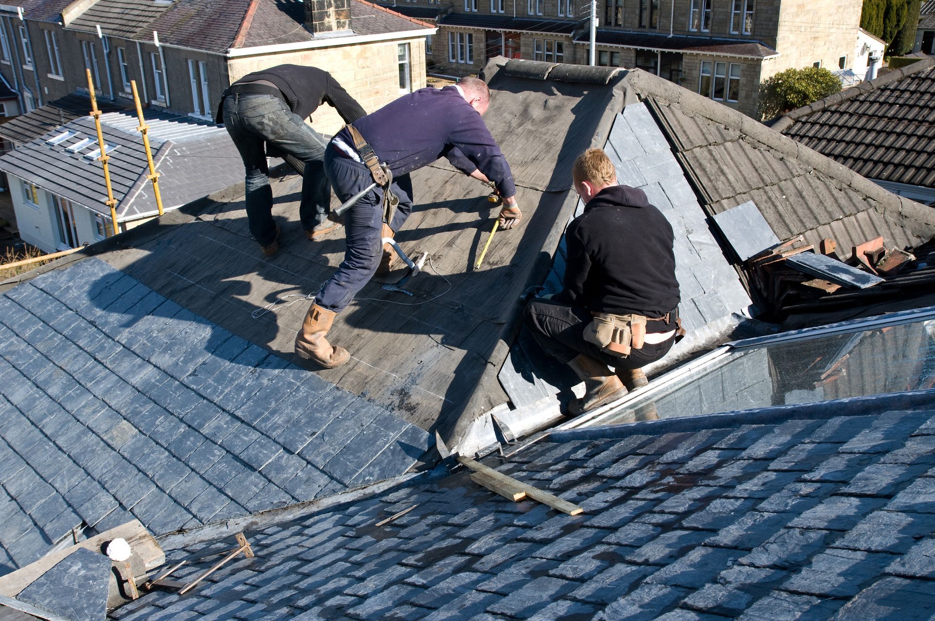 A group of men are working on a roof.