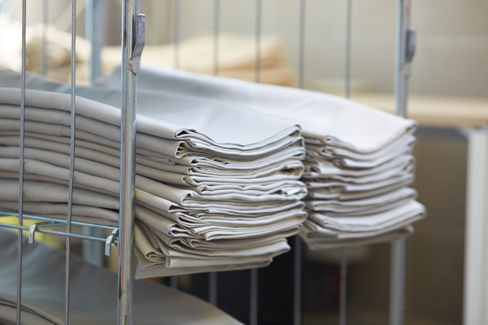 A Stack Of Towels Is Sitting On Top Of A Metal Rack — Buderim Laundrette In Buderim, QLD