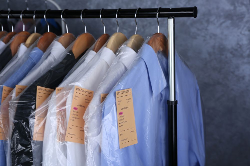 A Row Of Shirts Wrapped In Plastic Hang On A Rack — Buderim Laundrette In Mooloolaba, QLD