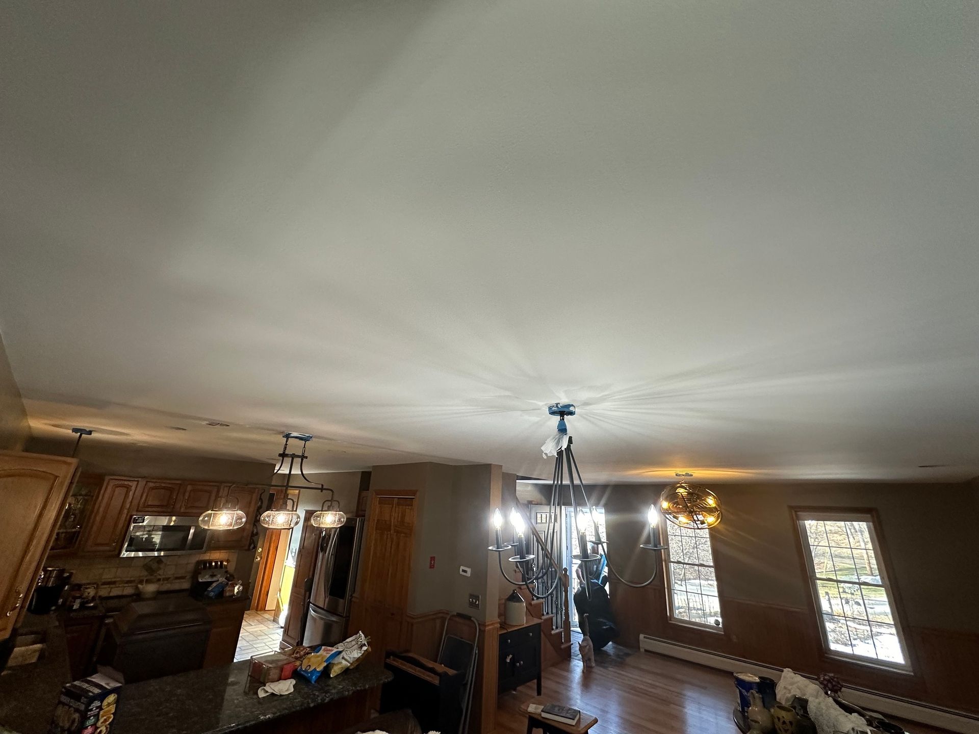 A living room with a ceiling fan and a chandelier.