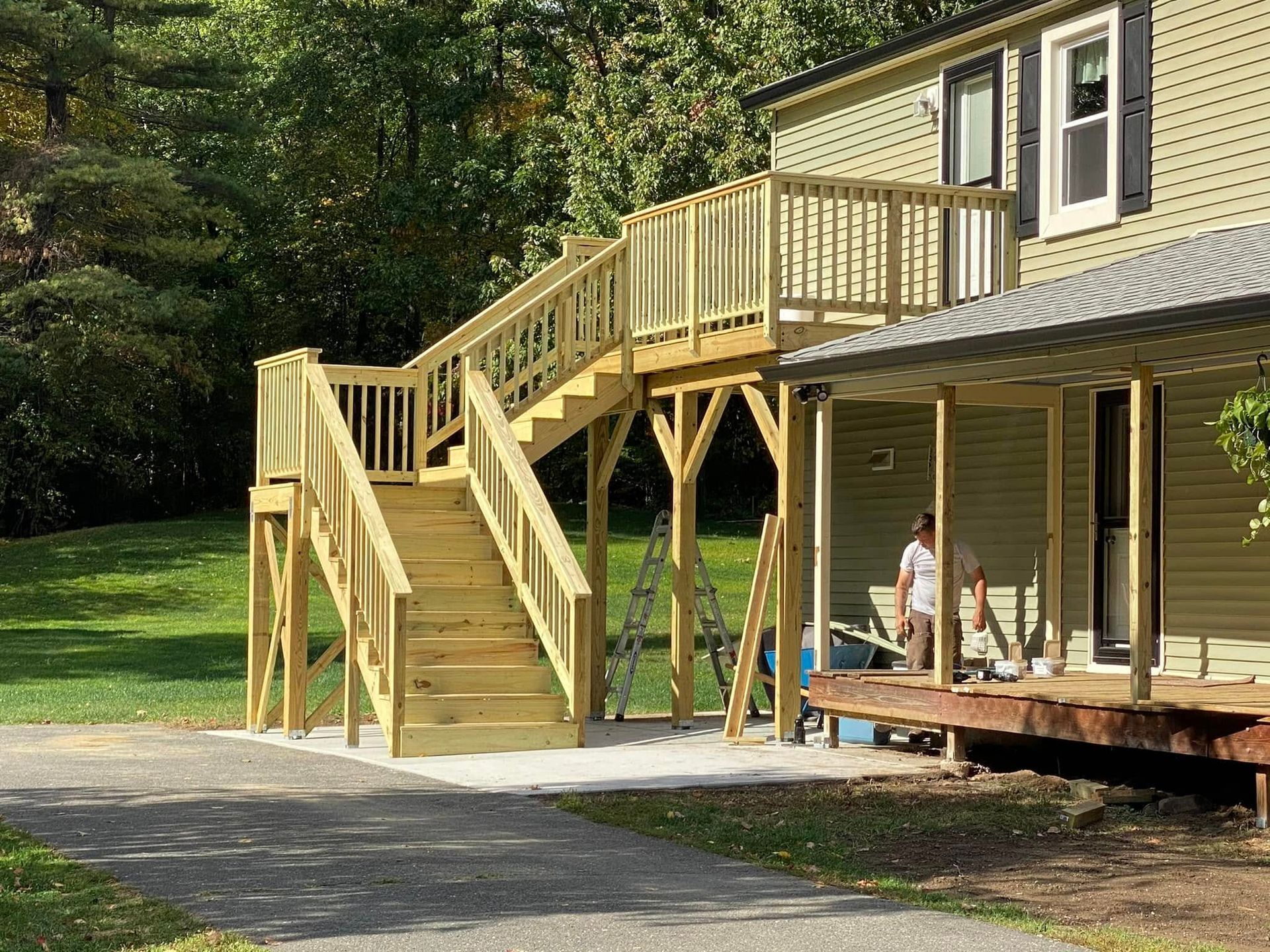 A wooden deck is being built on the side of a house.
