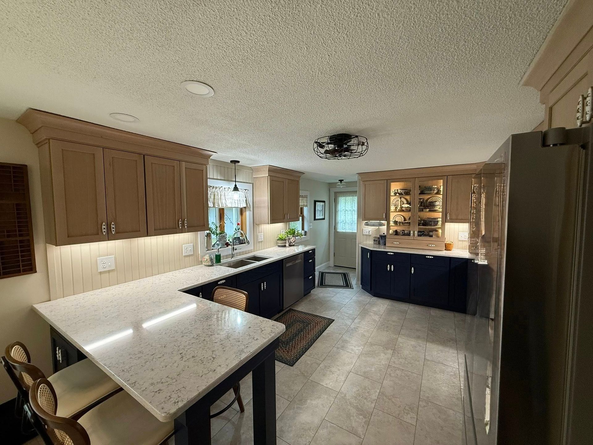 A kitchen with a table and chairs and a refrigerator.