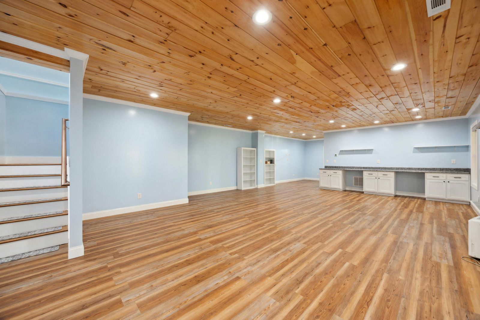 A large empty room with wooden floors and a wooden ceiling.