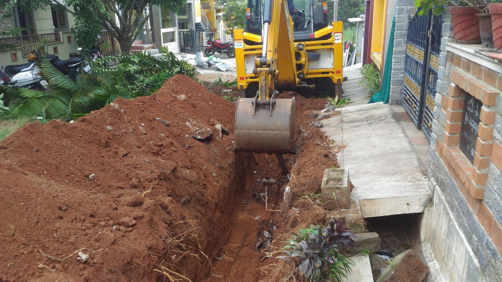 A yellow excavator is digging a hole in the ground.