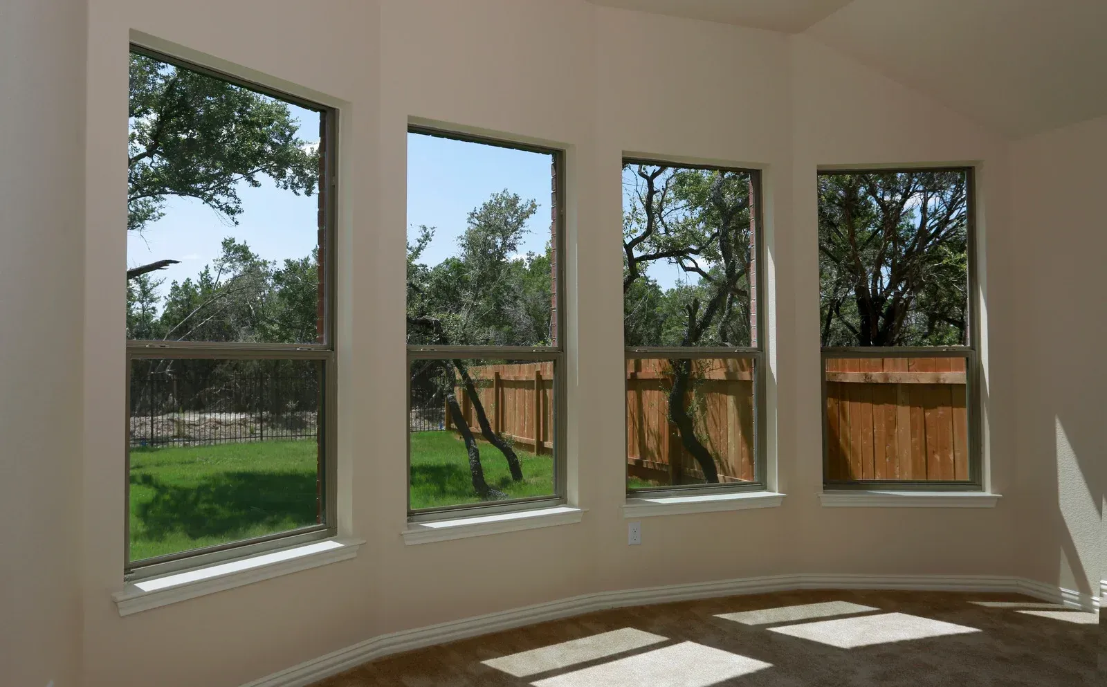 A room with a lot of windows and a fence in the background