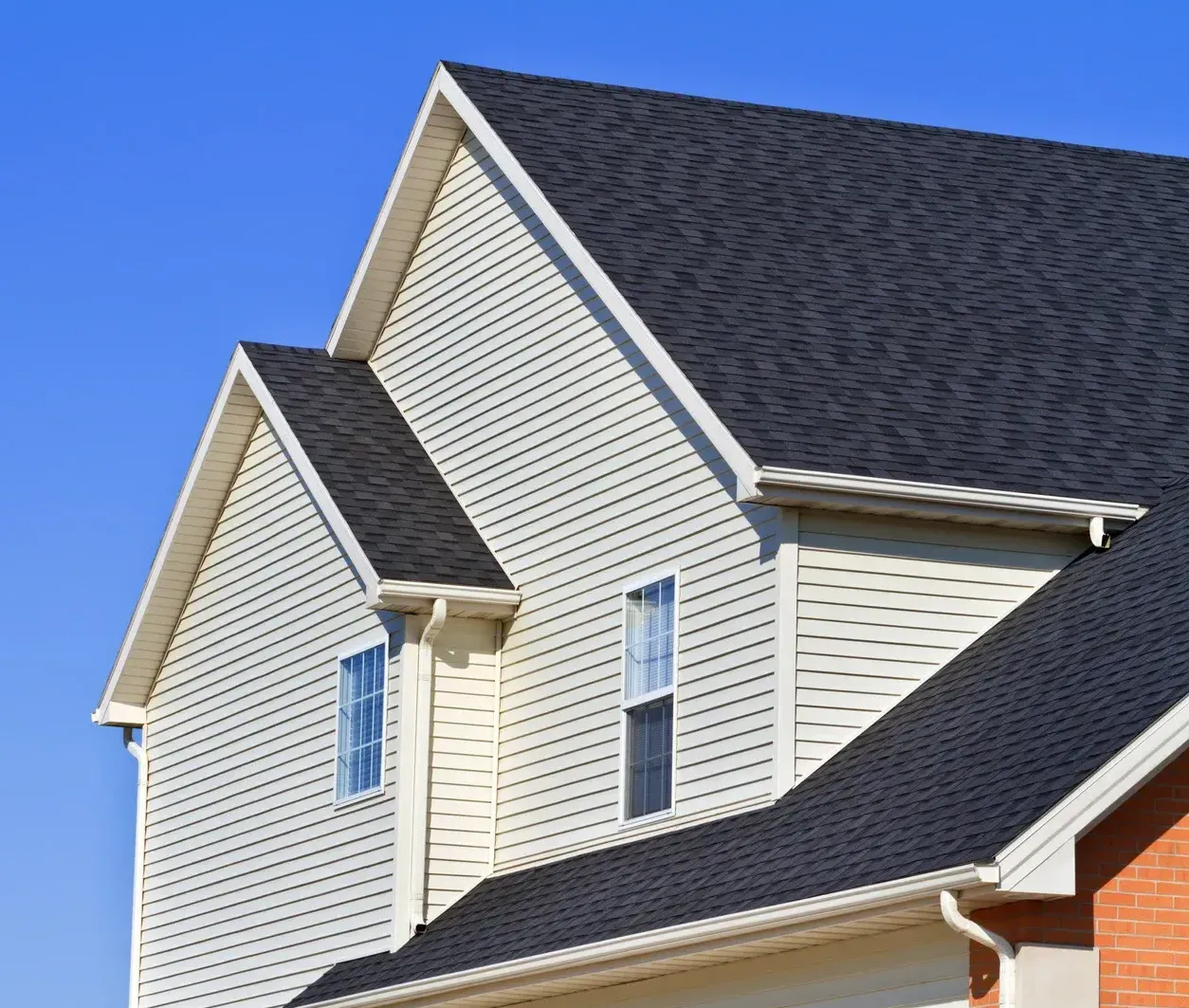 A house with a black roof and white siding