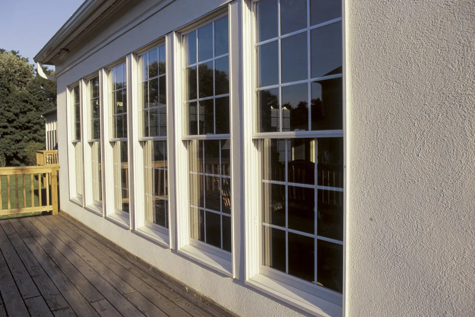 A house with a lot of windows and a wooden deck