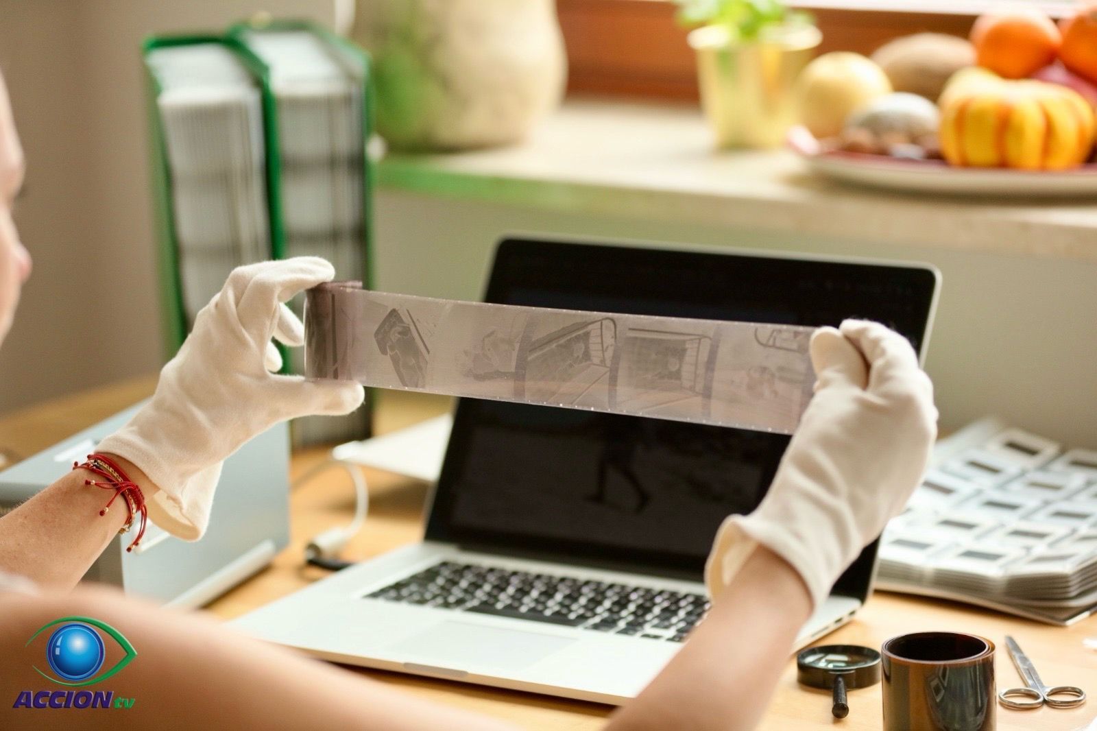 Una mujer sostiene un trozo de papel frente a una computadora portátil.