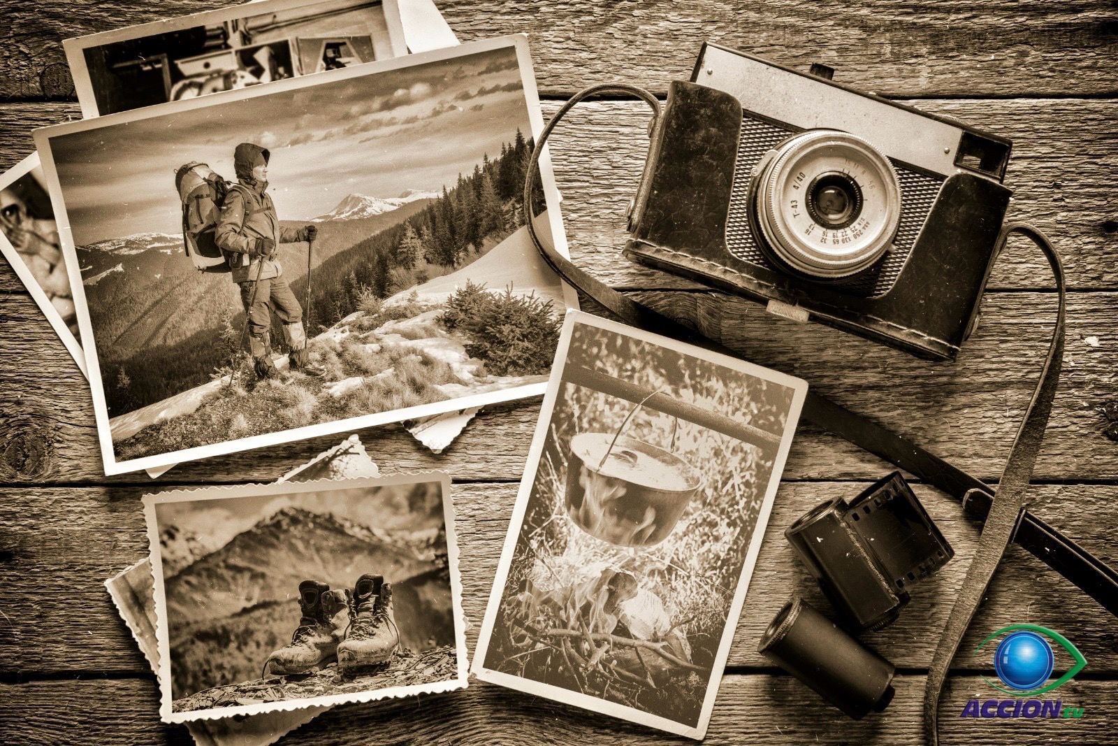 Una fotografía en blanco y negro de un hombre con una mochila y una cámara sobre una mesa de madera.
