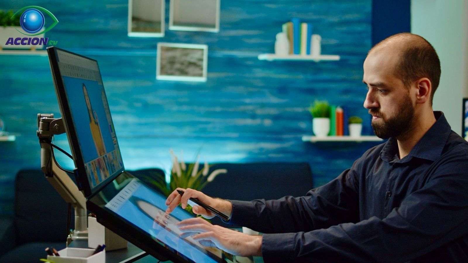 Un hombre está sentado en un escritorio usando una computadora.