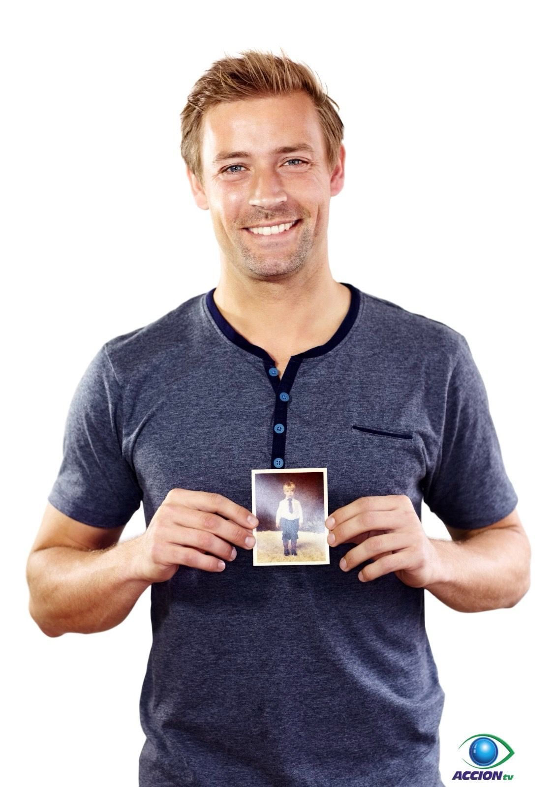 Un hombre con una camisa azul sostiene una foto de él mismo.