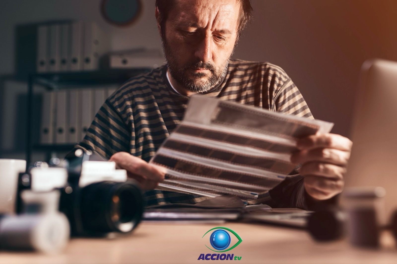 Un hombre está sentado en un escritorio mirando un trozo de papel.