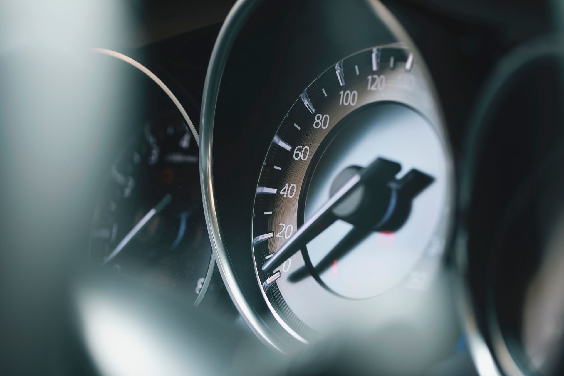A black car is driving down a foggy highway.