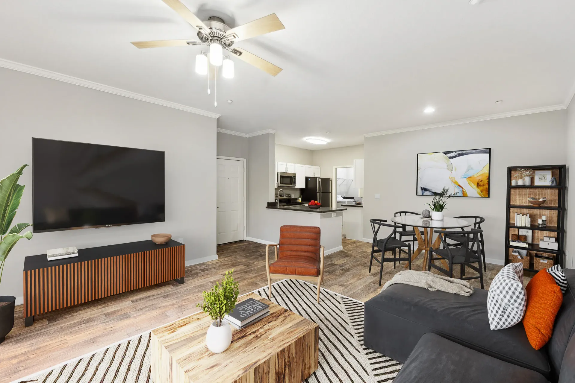 Open-concept living area in a modern apartment with TV, sofa, and dining table.