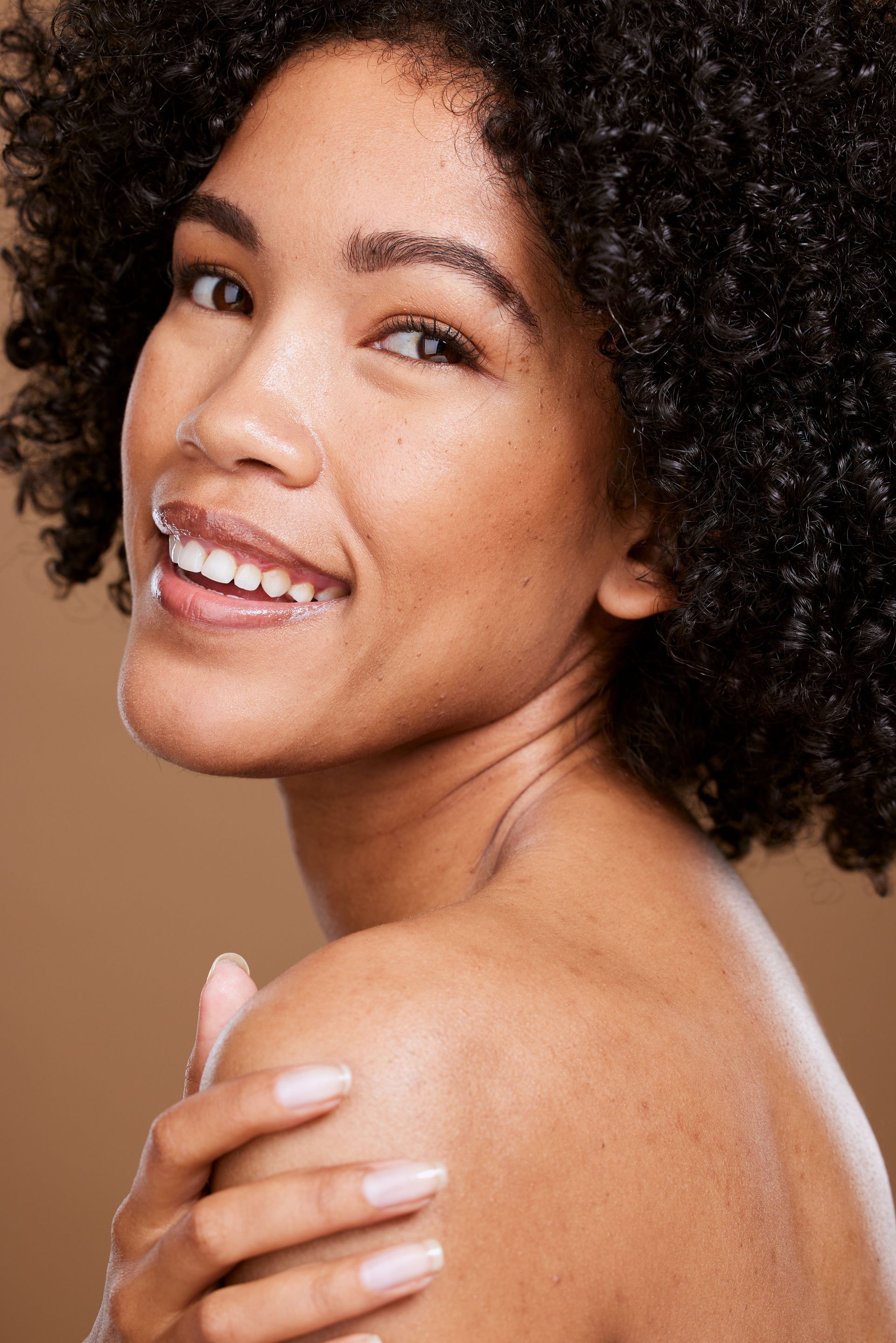 a woman is covering her face with her hands and smiling .