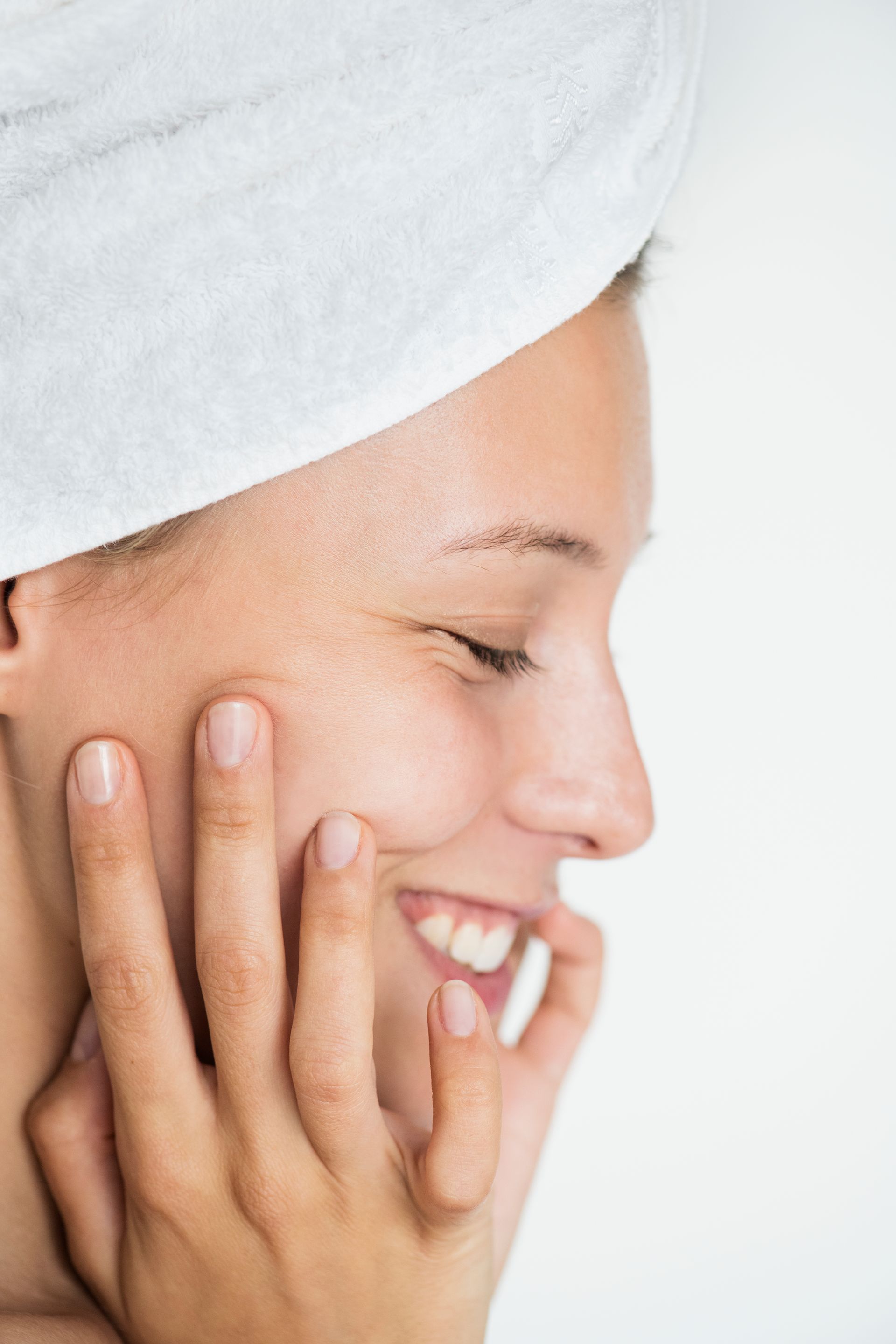 a woman is covering her face with her hands and smiling .