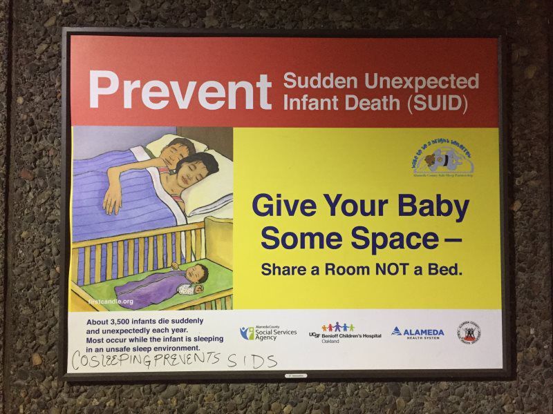 Sign: Prevent SUID. Illustration of parents in bed, baby in crib. 