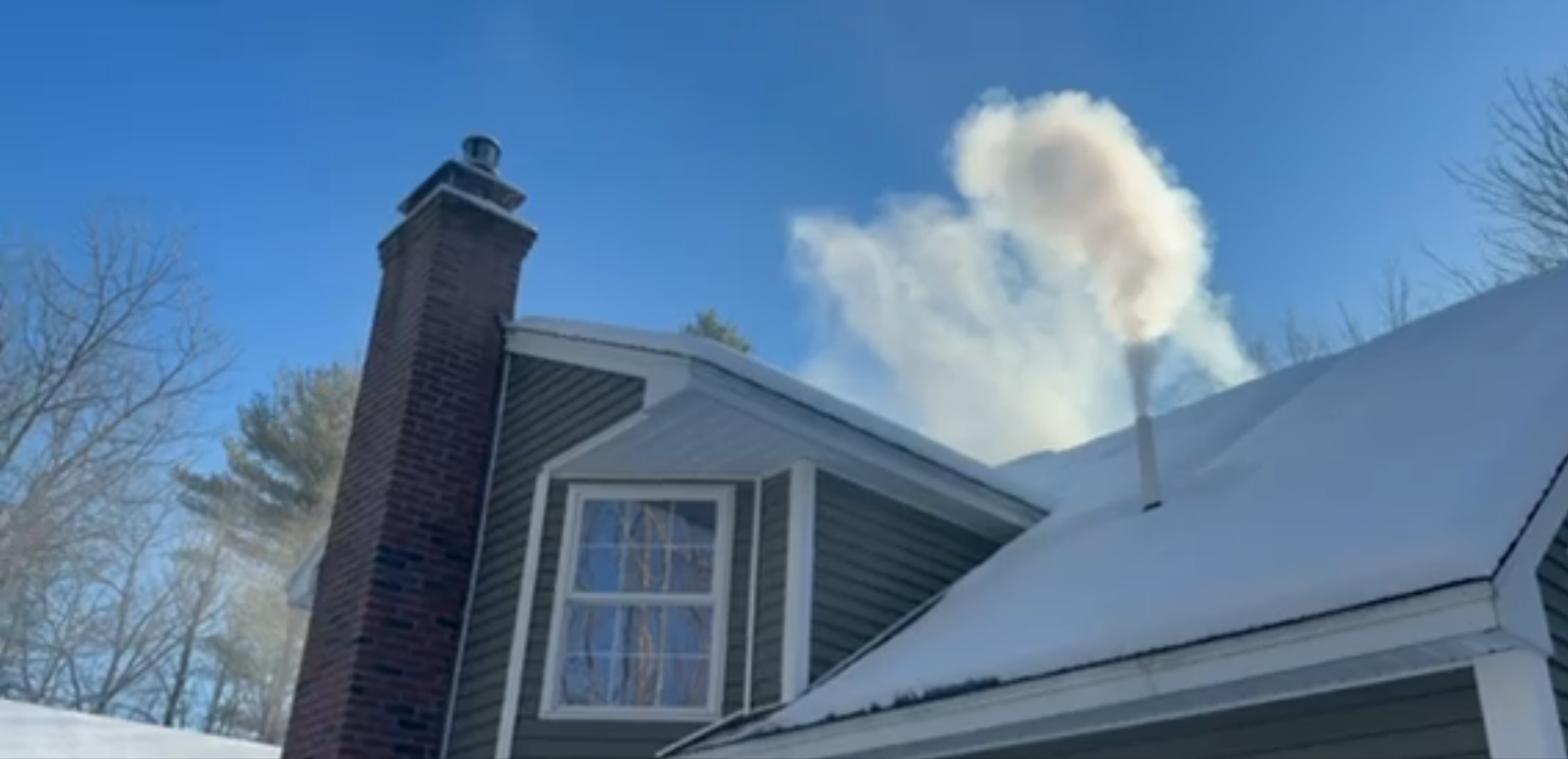 Blue and black sewer line inspection machine on a trailer, with a large hose reel and orange warning light.