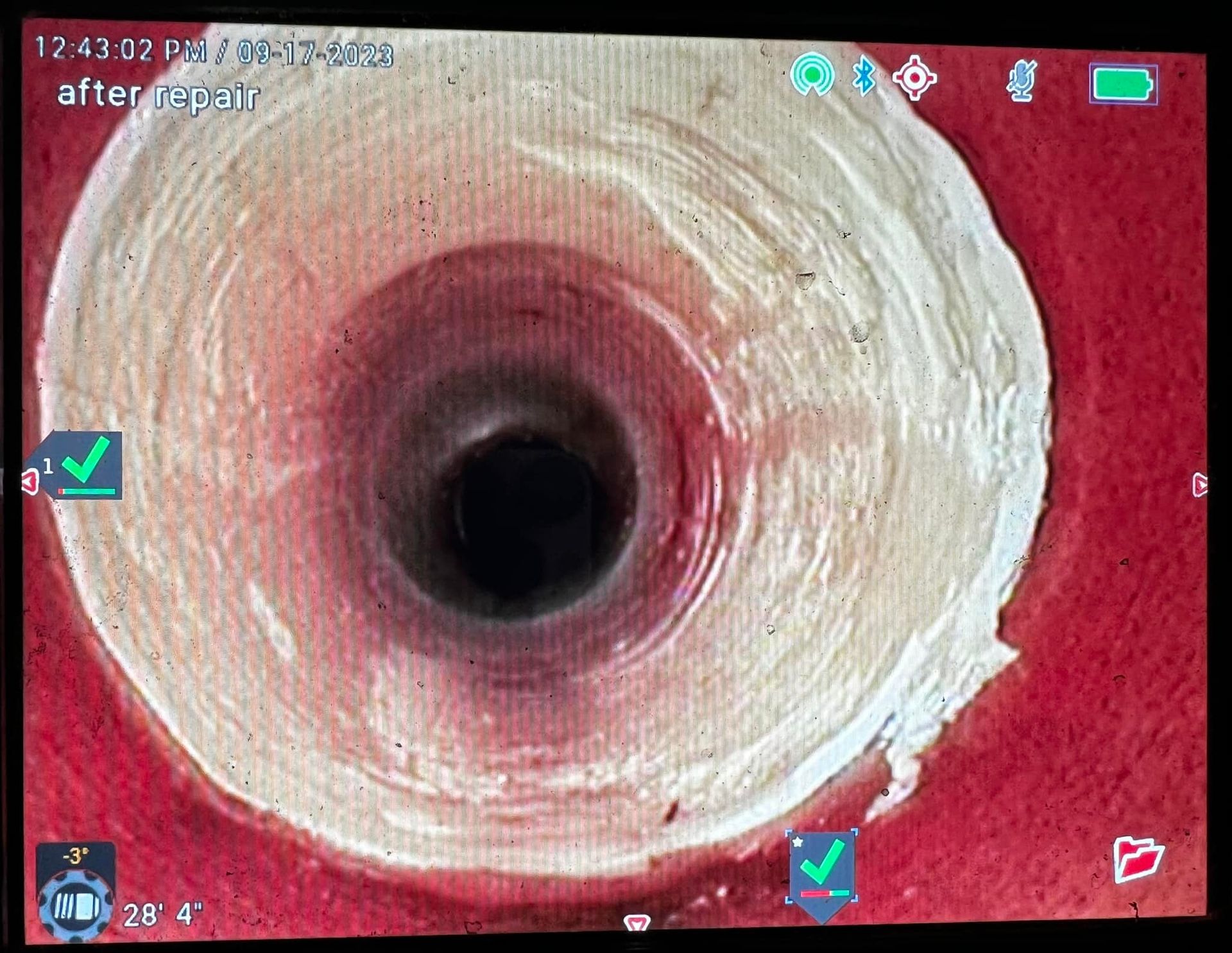 Man on a ladder installing a ceiling light in a kitchen