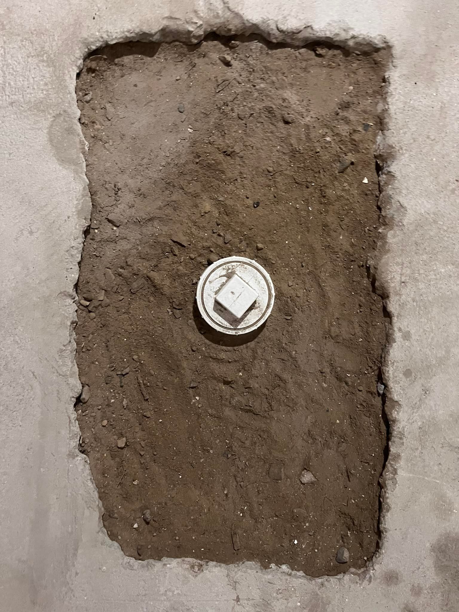 Man on a ladder installing a ceiling light in a kitchen
