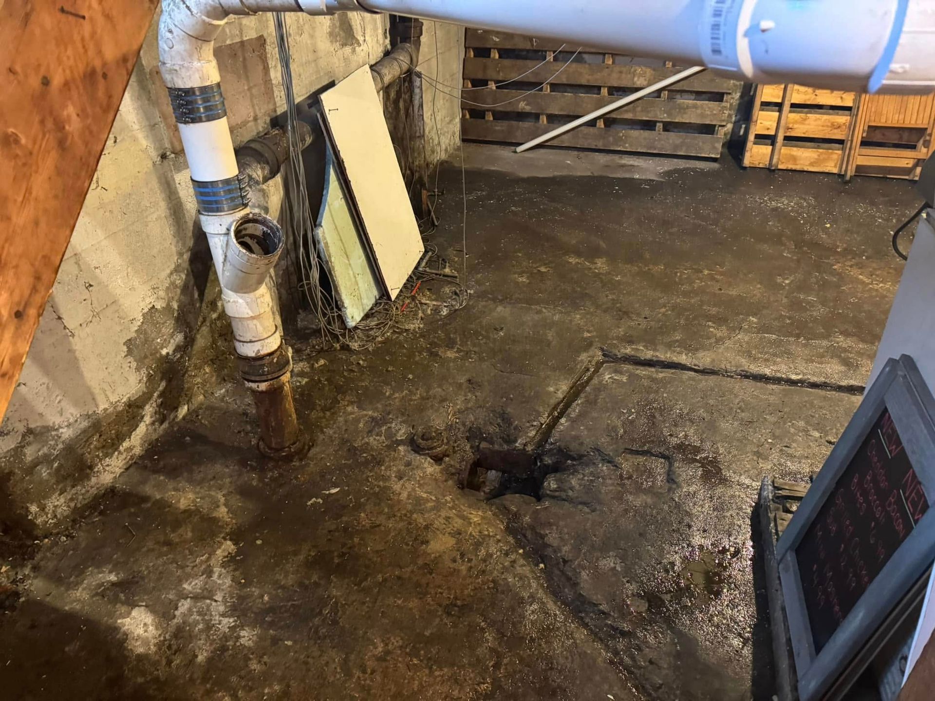 Man on a ladder installing a ceiling light in a kitchen