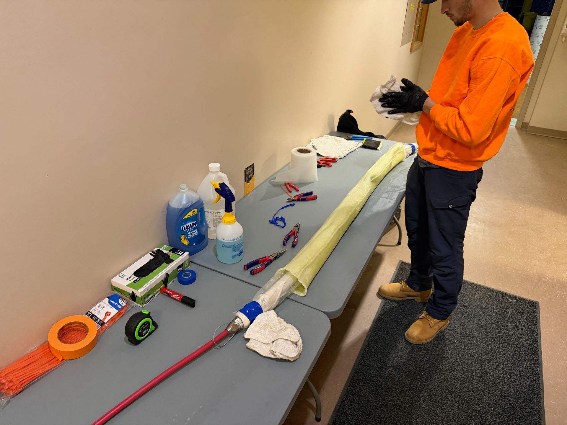 Man on a ladder installing a ceiling light in a kitchen