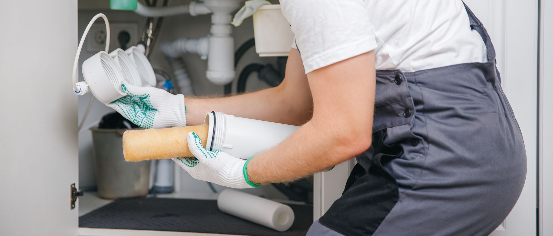 Person in white gloves placing a foam cylinder into a machine opening for a product inspection