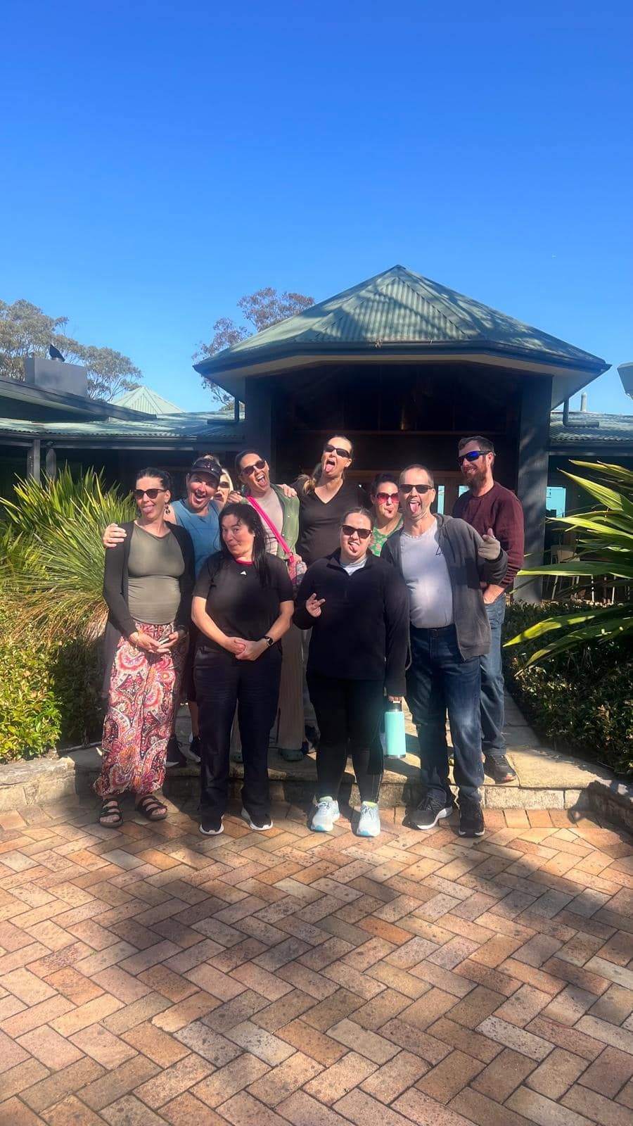 A group of people are posing for a picture in front of a building.