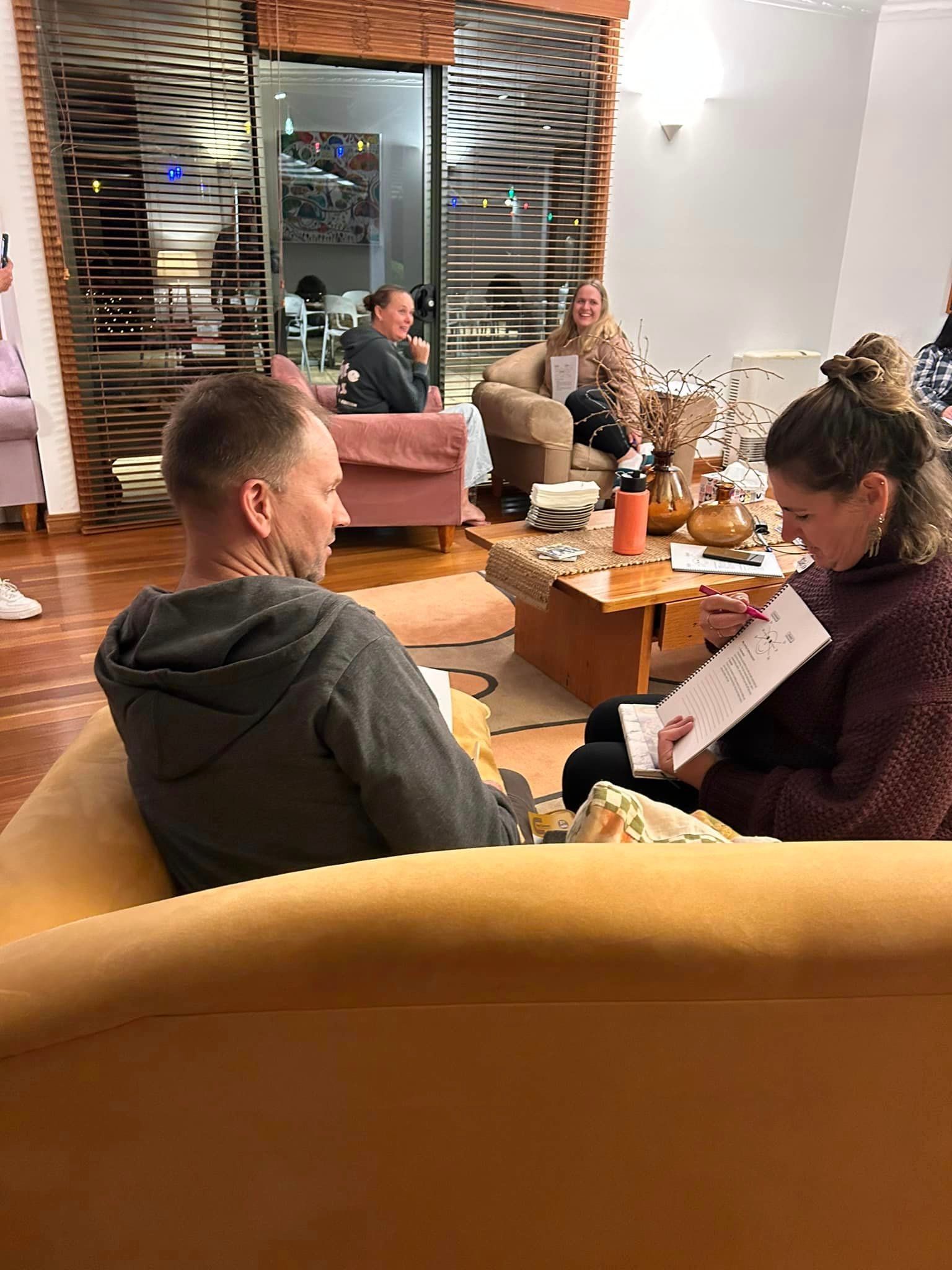 A man and a woman are sitting on a couch in a living room.