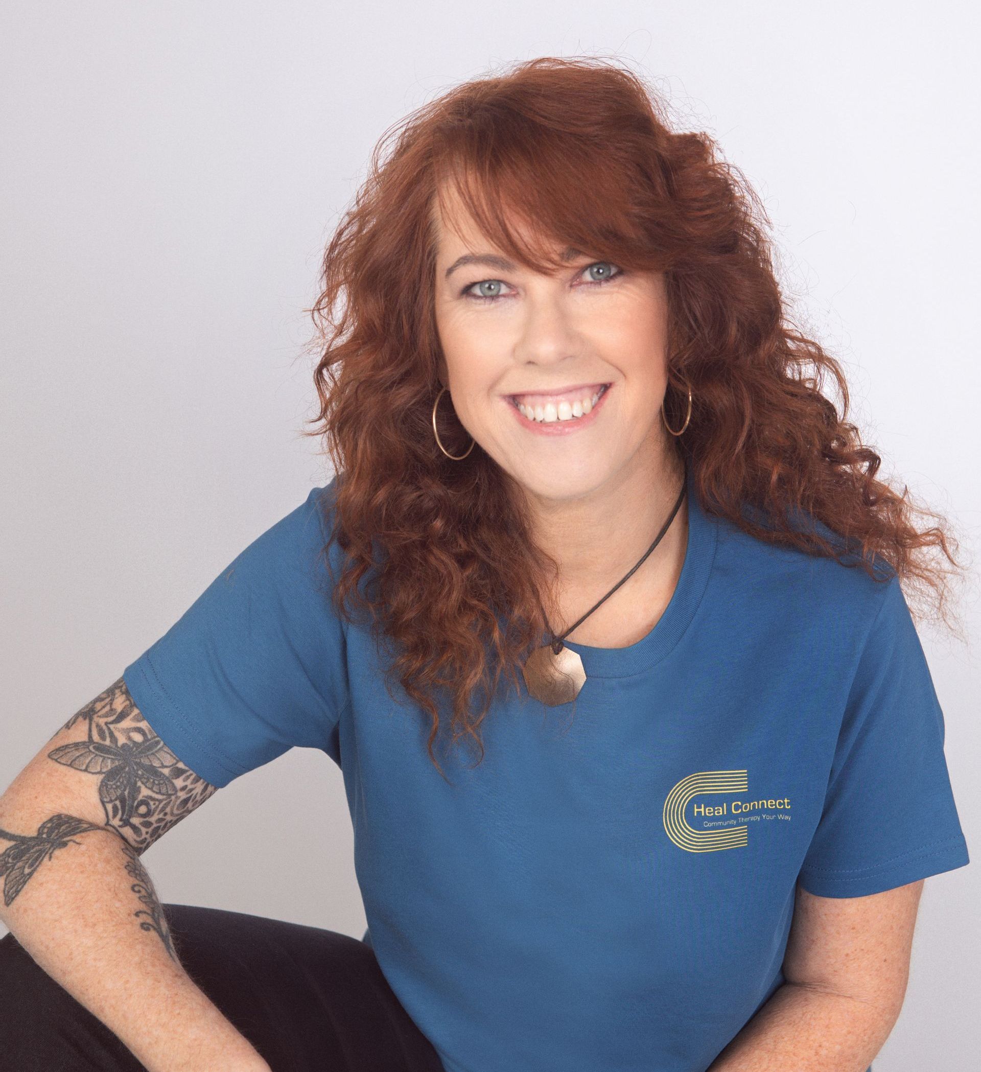 A woman with red hair is wearing a blue shirt