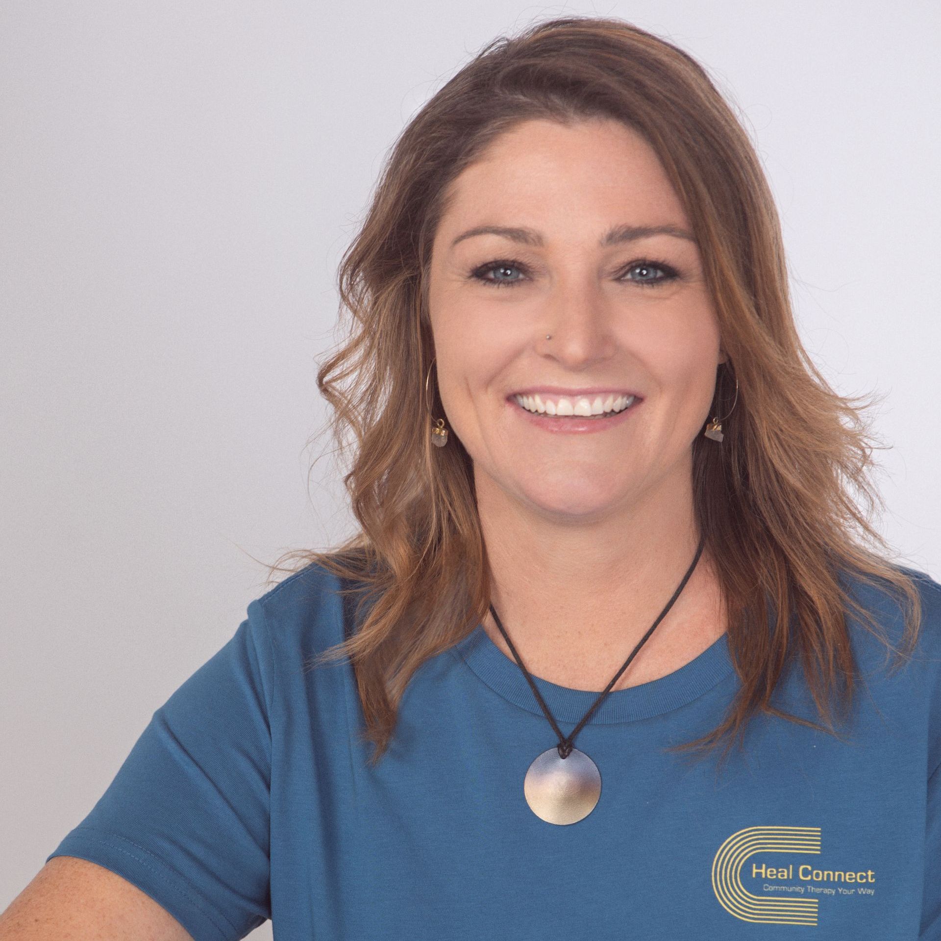 A smiling woman wearing a blue shirt that says hair correct