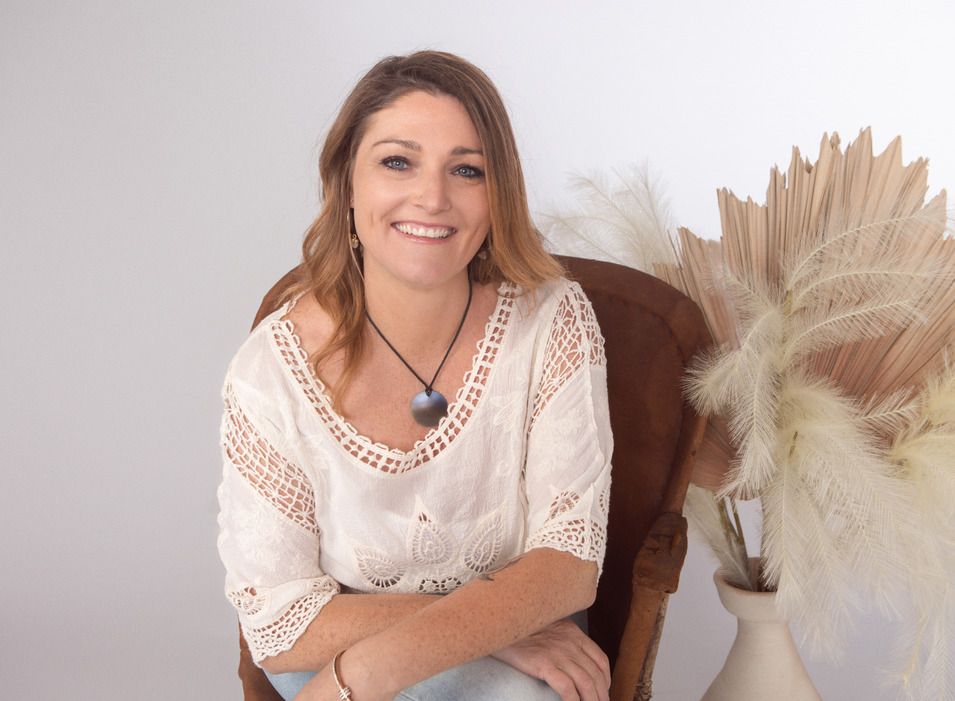 A Woman Is Sitting In A Chair Next To A Vase Of Flowers — Heal Connect in Long Jetty, NSW