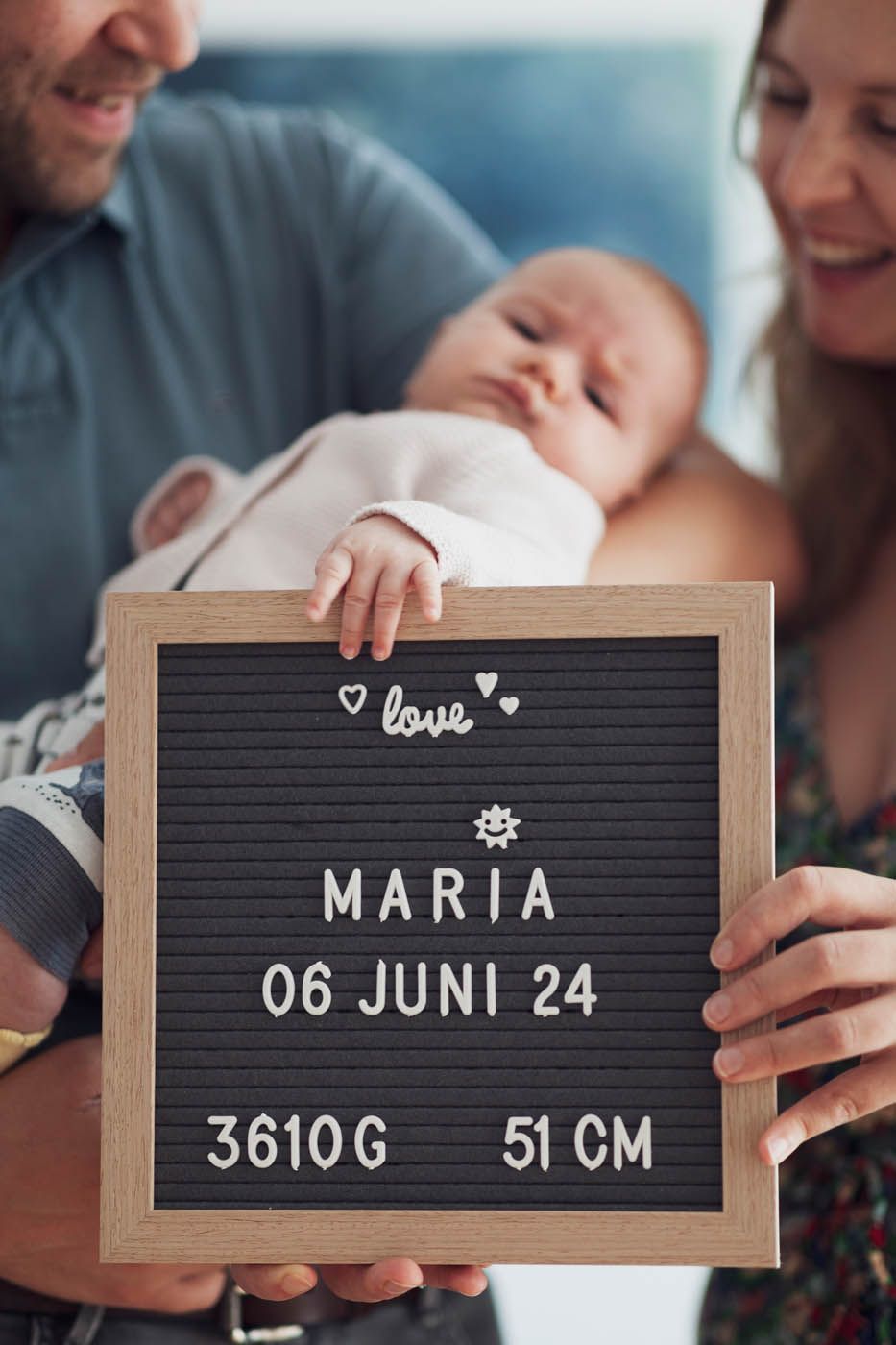 Eltern halten Baby Maria mit Geburtsdaten auf einem Schild: 06 Juni 24, 3610 g, 51 cm.