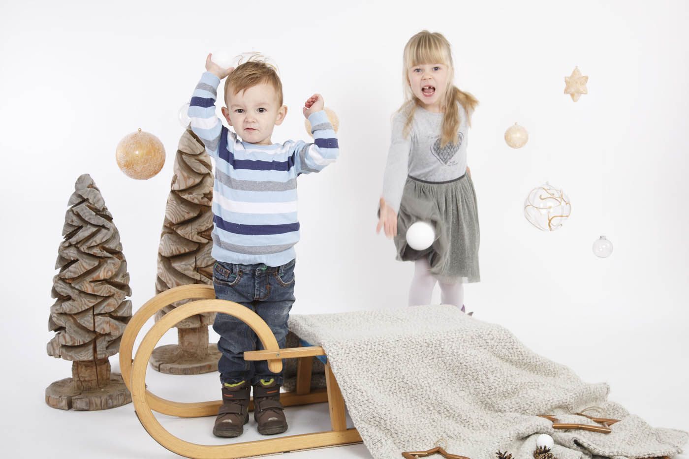 Zwei Kinder spielen in einer Winterlandschaft im Fotostudio