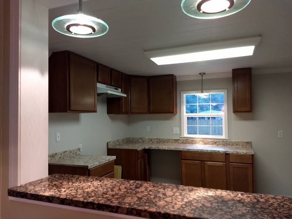 A kitchen with wooden cabinets and granite counter tops