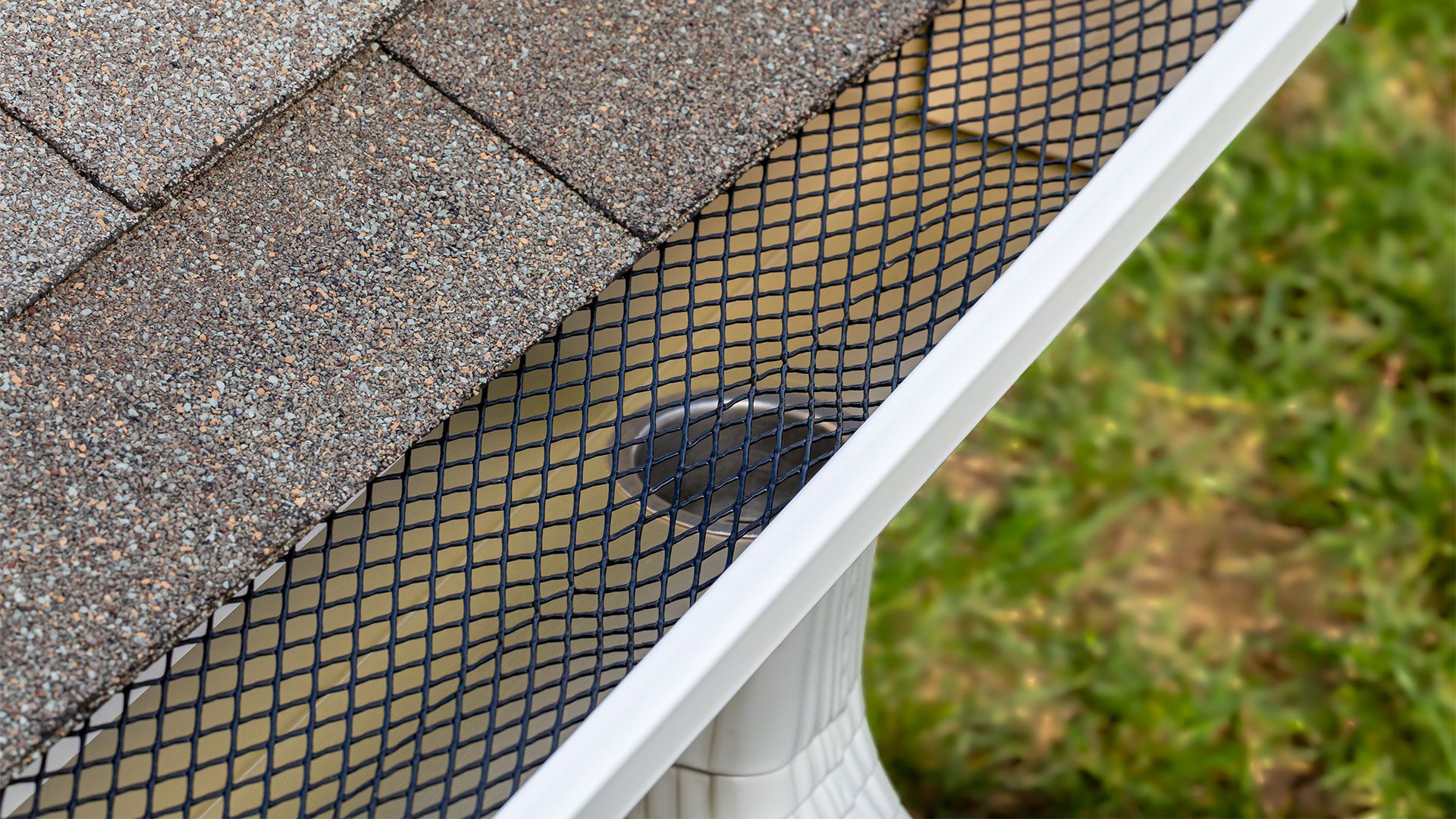 A close up of a gutter with a mesh on it.