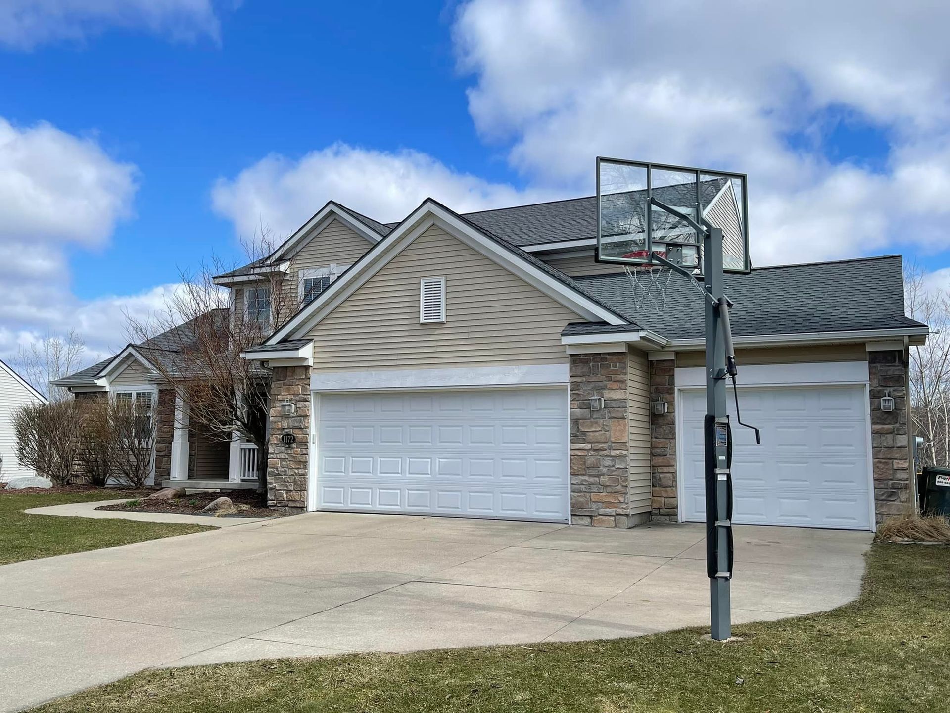 A large house with a basketball hoop in front of it.