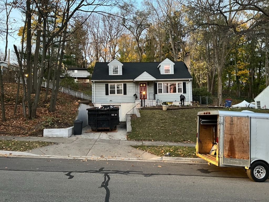 A house with a trailer parked in front of it.