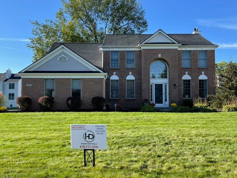 A large brick house with a sign in front of it.