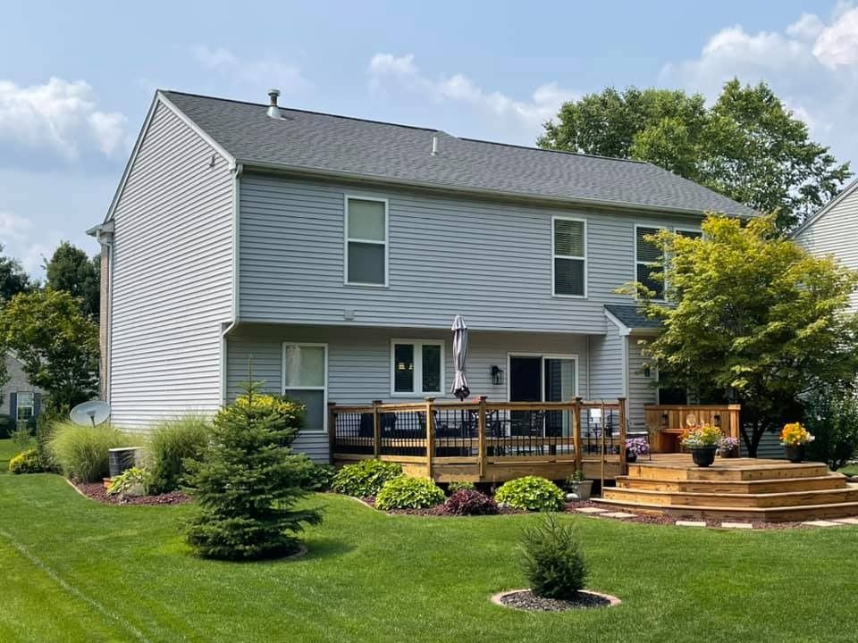 A large house with a large deck in the backyard.