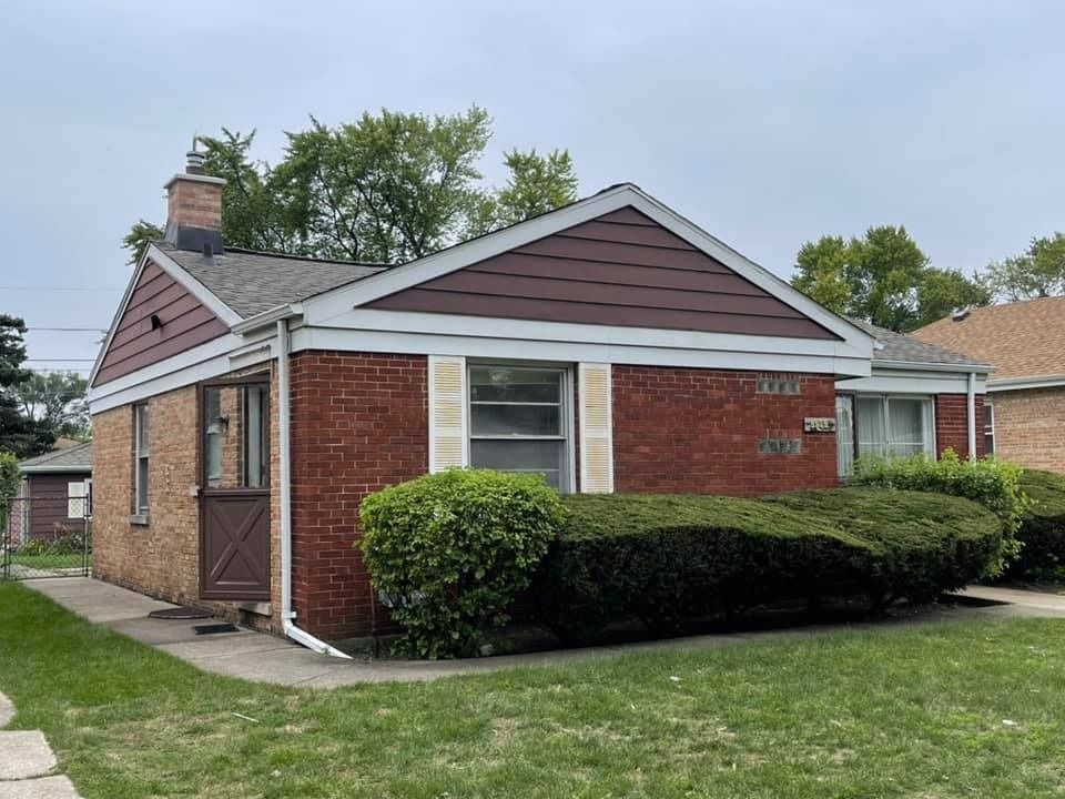 A small brick house with a chimney on the roof is for sale.