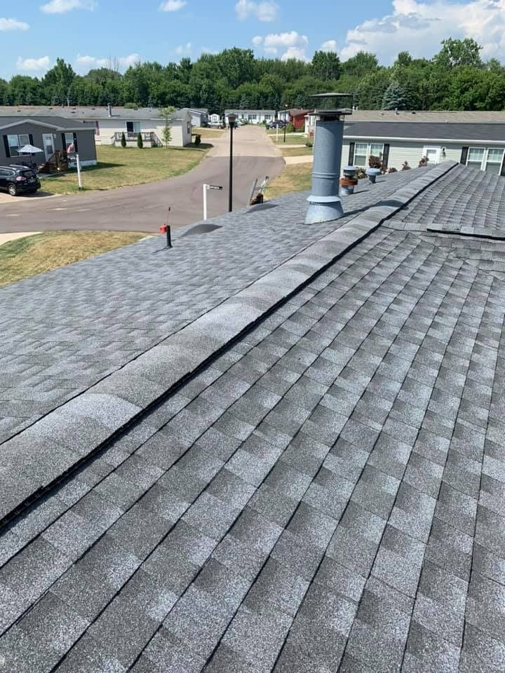 A roof with a chimney on it and a lot of shingles on it.