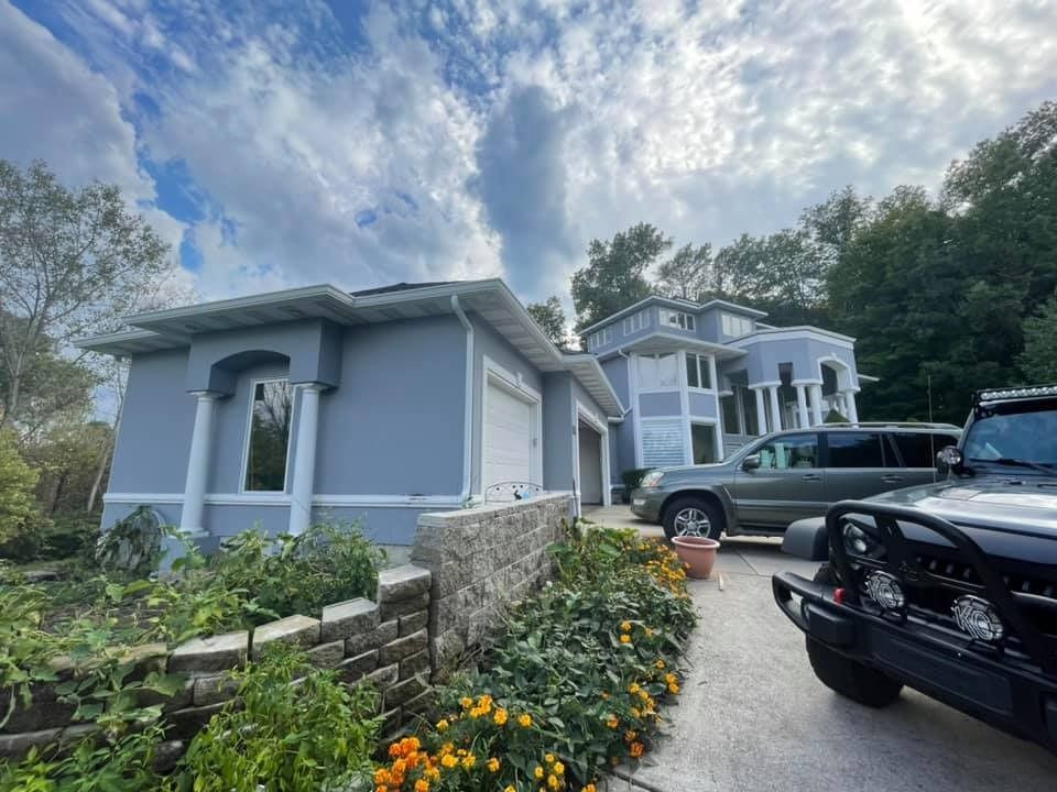 A jeep is parked in front of a large house.