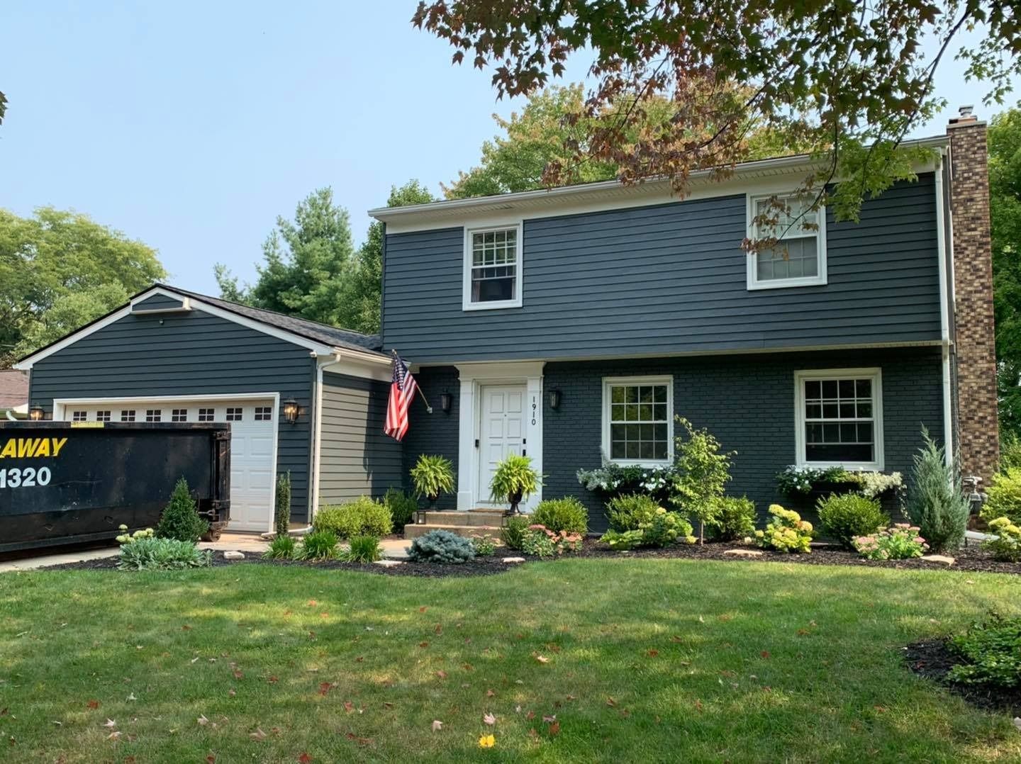 A large house with a dumpster in front of it.
