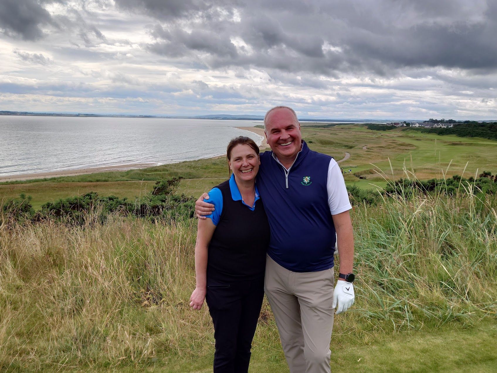 Golftas met clubs op groen gras, fel zonlicht en een wazige achtergrond van bomen.