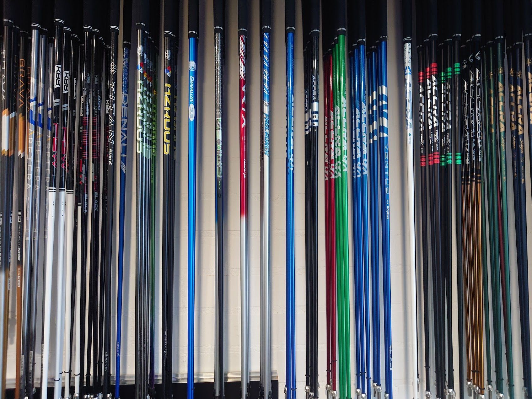 Een golfer knielt op de green en bekijkt een putt. 