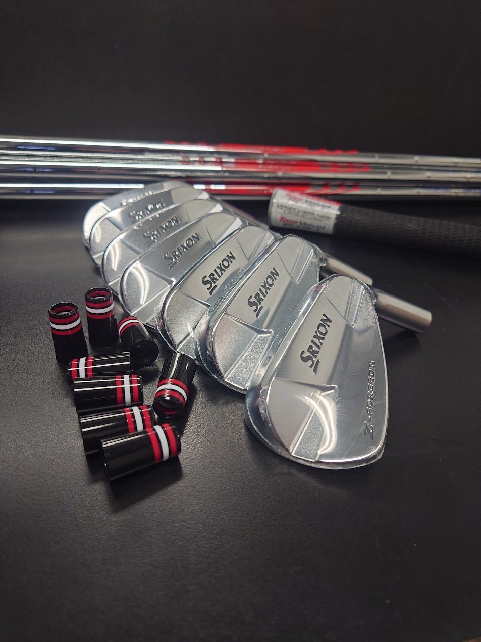 Een man in golfkleding poseert op een pad, met een putter in zijn hand. 